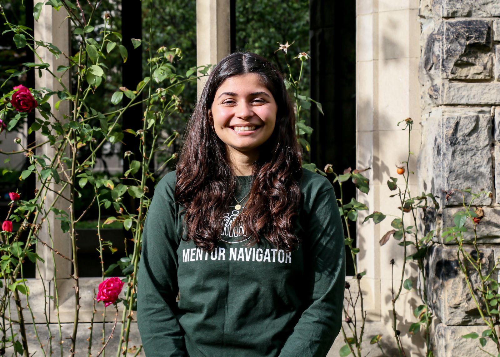 Photograph of Alejandra (Mentor Navigator) standing in front of the University of Toronto campus.